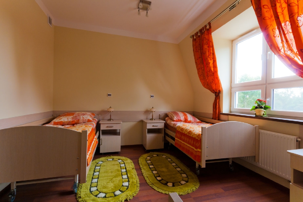 Pokoje w Prywatnym Domu Opieki „Tęczowe Wzgórze” w Woli Wodyńskiej są przytulne i utrzymane w ciepłej kolorystyce, dzięki czemu seniorzy mogą poczuć się jak w domu