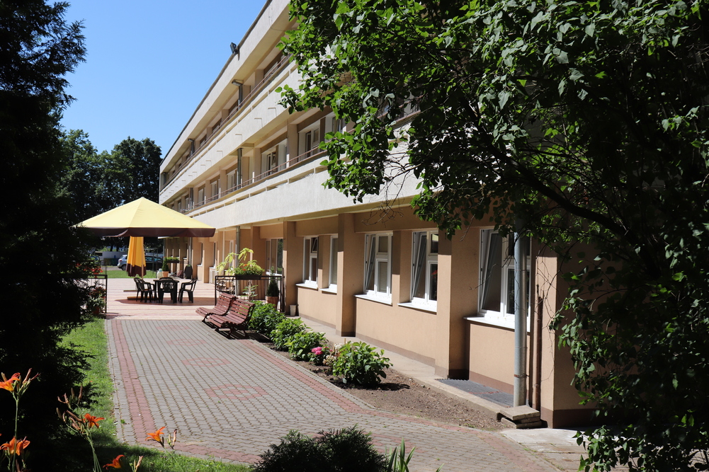 Przed budynkiem Domu Pomocy Społecznej w Inowrocławiu znajdują się ławeczki, a latem personel wystawia stół z krzesłami i parasol