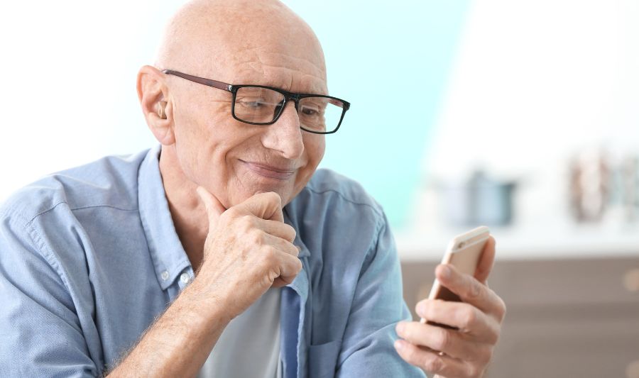 Newsletter – co to jest? Na zdjęciu senior czytający newsletter.