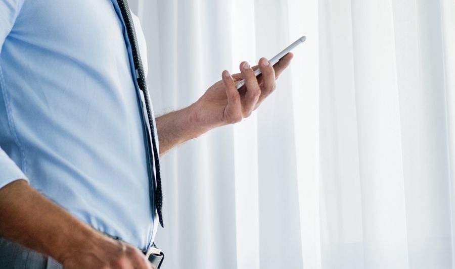 Mężczyzna zauważa na smartfonie komunikat "nie możesz wysłać wiadomości do tego konta" we Messengerze.