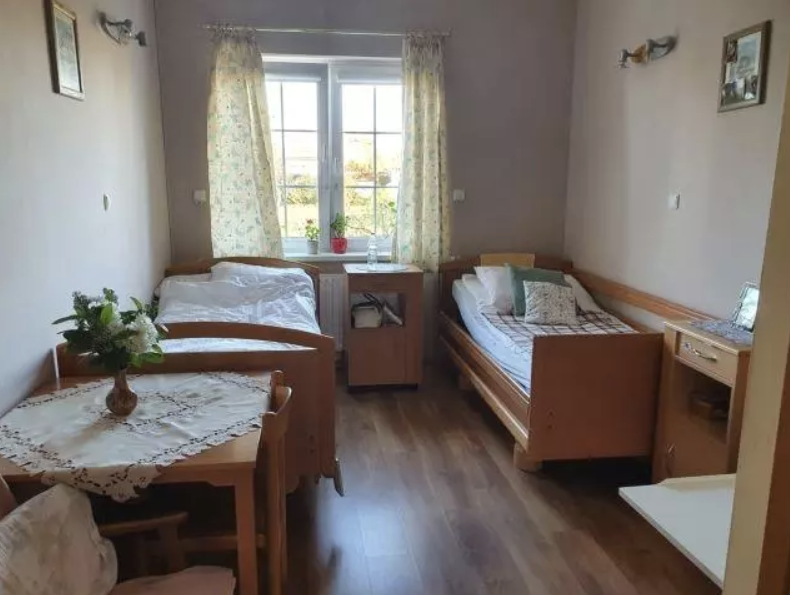 Pokoje w Domu Seniora Tęcza w Łapinie Kastuskim są wyposażone w łóżka medyczne i niezbędne meble