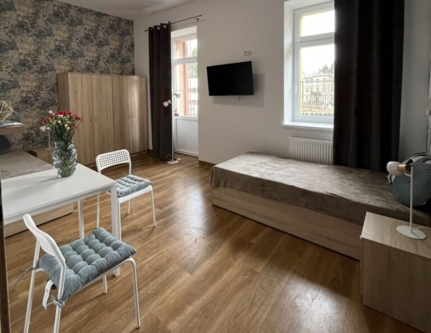 W pokojach mieszkańców Cieplickiej Rezydencji Seniorów w Jeleniej Górze znajdują się wygodne łóżka, telewizor, a także balkon